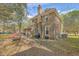 Two-story brick home featuring a spacious backyard and inviting outdoor patio with a grill at 140 Wampee Curve, Summerville, SC 29485