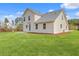 This home features a large green lawn, back patio, and light yellow vinyl siding for a charming exterior at 153 Mitch Ln, Holly Hill, SC 29059