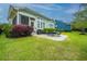 Landscaped backyard featuring a screened porch, stone patio, and outdoor dining area with lush green grass at 1543 Watoga Way, Mount Pleasant, SC 29466