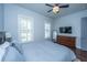 Bright bedroom featuring shuttered windows, ceiling fan, flatscreen TV, and hardwood floors at 1543 Watoga Way, Mount Pleasant, SC 29466