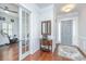 Welcoming foyer showcasing hardwood floors, paneled walls, elegant decor, and a glimpse into a versatile workout space at 1543 Watoga Way, Mount Pleasant, SC 29466