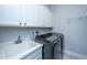Laundry room featuring modern washer and dryer, utility sink, and white storage cabinets at 1543 Watoga Way, Mount Pleasant, SC 29466