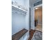 Well-organized mudroom with dark-stained bench, hooks, shelves, and tiled floors at 1543 Watoga Way, Mount Pleasant, SC 29466