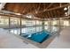 Indoor pool with vaulted wood ceilings, plenty of lighting, and floor-to-ceiling windows overlooking the scenery at 157 High Hammock Villas, Seabrook Island, SC 29455