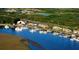 Aerial shot of marina featuring boat docks and waterfront restaurant set amidst lush greenery at 157 High Hammock Villas, Seabrook Island, SC 29455