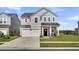 Charming two-story home featuring a spacious front lawn, attached garage, and welcoming entryway with decorative wreath at 157 Tuscan Sun St, Summerville, SC 29485