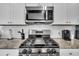 Close-up of the stainless steel range and microwave with granite countertops and subway tile backsplash at 157 Tuscan Sun St, Summerville, SC 29485