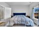 This bedroom features a large blue bed set, carpet floors, and a door that leads to the bathroom at 157 Tuscan Sun St, Summerville, SC 29485