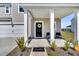 Cozy front porch with seating, decorative wreath on the front door, and manicured landscaping at 157 Tuscan Sun St, Summerville, SC 29485