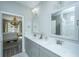 Bright bathroom featuring double sinks, neutral tones, and a view into the bedroom with a chandelier at 159 Garden Gate Way, Summerville, SC 29486