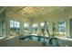 Relax in the sunlit indoor spa area featuring a handicap lift, surrounded by large windows and serene views at 159 Garden Gate Way, Summerville, SC 29486