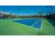 Vibrant blue and green tennis courts with street lights, adjacent to a building with palm trees at 159 Garden Gate Way, Summerville, SC 29486