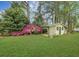 Spacious backyard featuring a quaint shed surrounded by lush greenery and colorful azaleas at 1636 Pinopolis Rd, Moncks Corner, SC 29461