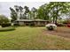 Charming brick home featuring a landscaped front yard with mature trees and colorful flowering bushes at 1636 Pinopolis Rd, Moncks Corner, SC 29461