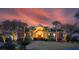 Beautifully lit front exterior of home with manicured lawn, palm trees, and ample foliage in landscaping at 1644 Omni Blvd, Mount Pleasant, SC 29466