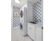 Well-lit laundry room featuring a stacked washer and dryer and stylish blue and white wallpaper at 1644 Omni Blvd, Mount Pleasant, SC 29466