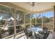 Screened-in porch with ceiling fan, seating, and wooded views at 1644 Omni Blvd, Mount Pleasant, SC 29466