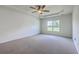 Bedroom featuring tray ceilings, plush carpet, neutral paint, and large windows showcasing a picturesque outdoor view at 189 Weeping Cypress Dr, Moncks Corner, SC 29461