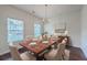 Formal dining room boasts a wooden table set for six, a decorative chandelier, and two large windows at 189 Weeping Cypress Dr, Moncks Corner, SC 29461