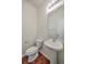Cozy half-bathroom with stylish sink, toilet, mirror, and sleek vanity light and hardwood floors at 189 Weeping Cypress Dr, Moncks Corner, SC 29461