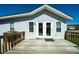 A house with a wooden back deck and white siding under a bright blue sky at 1908 Palmetto Boulevard Blvd, Edisto Island, SC 29438