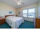 Bright bedroom features a floral patterned bedspread, ceiling fan, and sunny window at 1908 Palmetto Boulevard Blvd, Edisto Island, SC 29438