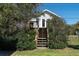 Inviting home with a wooded staircase leading to a front porch and ample privacy at 1908 Palmetto Boulevard Blvd, Edisto Island, SC 29438