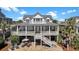 Inviting backyard with outdoor lounge chairs on brick patio and spacious porch for relaxing or entertaining guests at 212 Ocean Blvd, Isle of Palms, SC 29451