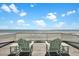 Relax on the balcony with Adirondack chairs overlooking the tranquil beach and ocean views at 212 Ocean Blvd, Isle of Palms, SC 29451
