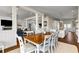 Open-concept dining area with hardwood floors, wooden dining table, white chairs, and view to kitchen and living room at 212 Ocean Blvd, Isle of Palms, SC 29451
