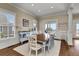 Bright dining room with wood table, white chairs, hardwood floors, and a beach view from windows and doors at 212 Ocean Blvd, Isle of Palms, SC 29451