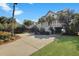 Long driveway leading to an elevated home with lush landscaping and covered parking at 212 Ocean Blvd, Isle of Palms, SC 29451