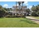 Stunning elevated beach house with lush landscaping and a spacious, well-manicured front yard at 212 Ocean Blvd, Isle of Palms, SC 29451