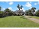 Lush front yard and charming two-story home, with palm trees and a well-manicured lawn at 212 Ocean Blvd, Isle of Palms, SC 29451