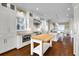 Bright, open kitchen with white cabinetry, stainless steel appliances, butcher block island, and hardwood floors, perfect for cooking at 212 Ocean Blvd, Isle of Palms, SC 29451
