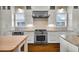 Well-equipped kitchen with stainless steel range, white cabinets, neutral backsplash, granite counters, and hardwood floors at 212 Ocean Blvd, Isle of Palms, SC 29451