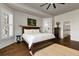 Spacious bedroom features hardwood floors, a ceiling fan, large windows with plantation shutters, and a view to bath area at 212 Ocean Blvd, Isle of Palms, SC 29451
