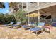 Relaxing backyard patio area with comfortable lounge chairs and an umbrella table at 212 Ocean Blvd, Isle of Palms, SC 29451