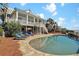 Backyard with a spacious pool, patio, lush landscaping, and luxurious lounge chairs at 212 Ocean Blvd, Isle of Palms, SC 29451