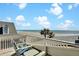Breathtaking view of the beach from the rooftop deck with Adirondack chairs and white railings at 212 Ocean Blvd, Isle of Palms, SC 29451