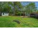 Beautiful backyard featuring a wooden shed, a pergola with a fire pit, and lush green grass with mature trees at 218 Candleberry Cir, Goose Creek, SC 29445