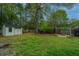 Spacious backyard featuring a wooden shed, a pergola with a fire pit, mature trees, and lush green grass at 218 Candleberry Cir, Goose Creek, SC 29445