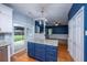 Modern kitchen with white cabinetry, stainless steel appliances, blue center island and seamless transition into the adjacent living space at 218 Candleberry Cir, Goose Creek, SC 29445