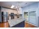 Open-concept kitchen with stainless steel appliances, white cabinetry, granite countertops, and a view of the backyard at 218 Candleberry Cir, Goose Creek, SC 29445