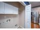 A tidy laundry area with white cabinets and connections, conveniently located near a modern stainless steel refrigerator at 218 Candleberry Cir, Goose Creek, SC 29445