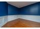This expansive living room features hardwood floors, white trim, and vibrant blue walls at 218 Candleberry Cir, Goose Creek, SC 29445