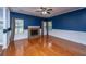 Spacious living room showcasing hardwood floors, custom trim work, and a classic fireplace with three large windows at 218 Candleberry Cir, Goose Creek, SC 29445