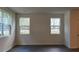 An airy bedroom featuring three windows and dark, wood-look flooring at 2405 Scarlett Maple St, Summerville, SC 29486