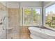 Elegant bathroom features a freestanding tub and glass shower, with window views at 2410 Kemway Rd, Johns Island, SC 29455