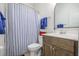 Bathroom features a shower with blue-striped curtain and a vanity with a dark wood cabinet at 2447 Louisville St, Charleston, SC 29492